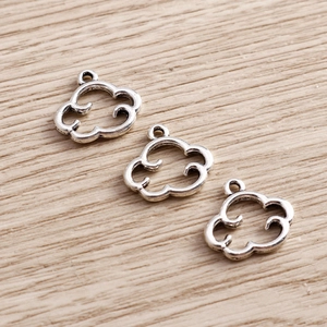 Detailed close-up of three vintage silver cloud pendants with hollow design for DIY jewelry