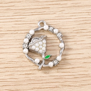 Detail of flower pendant with pearls, rhinestones, and green enamel for DIY jewelry