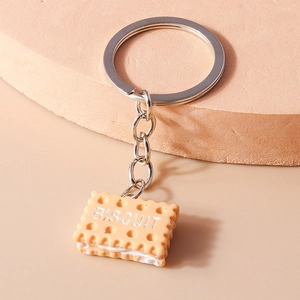 Realistic square biscuit keychain made of resin with silver metal ring on beige desk
