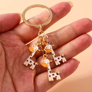 Joli porte-clés en métal doré avec trois pendentifs girafe en émail tenu à la main