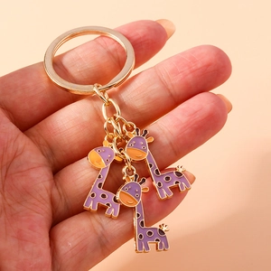 Porte-clés doré orné de trois mignons pendentifs girafes violets en émail brillant