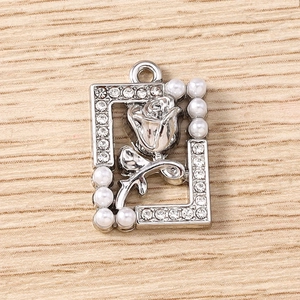Detail of silver rose pendant with white pearls and sparkling rhinestone border