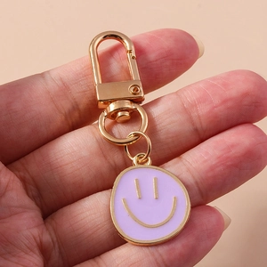 Gros plan d'un porte-clés smiley lavande avec un fermoir à ressort en métal doré en U