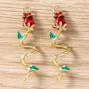 Detail of red rose charms with green enamel leaves and golden stems for jewelry making