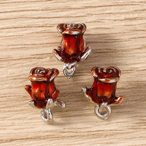 Macro detail of three 3D red rose flower pendants with silver alloy ring for DIY jewelry making