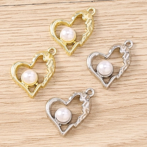 Dettaglio di ciondoli a cuore martellati oro e argento con perle per creazione gioielli