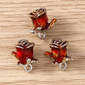 Detailed close-up of three gradient red and yellow rose flower charms with silver edges