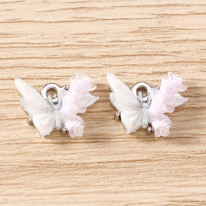 Close-up of DIY butterfly jewelry pendants with white and pink gradient pearl finish