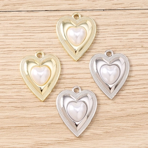 Dettaglio dei ciondoli a forma di cuore con bordo perlato e perla bianca per la creazione di gioielli