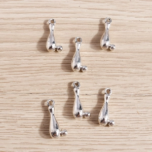 Vue macro de six breloques quilles de bowling en argent poli sur surface en bois