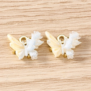 Macro view of butterfly resin charms with golden hanging loops for DIY jewelry making