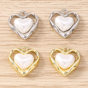 Vista dettagliata di ciondoli a cuore in perla con cornici in metallo oro e argento DIY