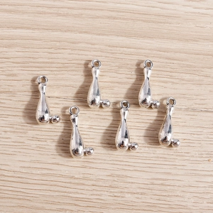 Gros plan de pendentifs quille et boule de bowling en métal argenté pour bijoux DIY