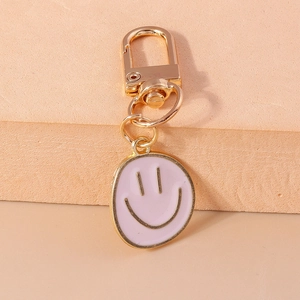 Détail d'un pendentif sourire en émail rose avec fermoir mousqueton doré sur porte-clés