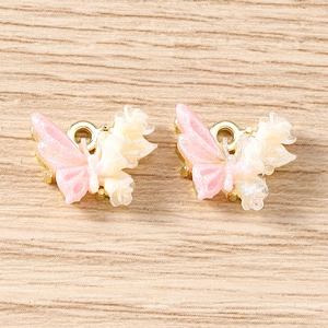 Macro detail of DIY resin butterfly charms with gold metal loops and glitter finish