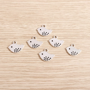 Detail of six vintage silver bird alloy charms with antique dot pattern for DIY jewelry