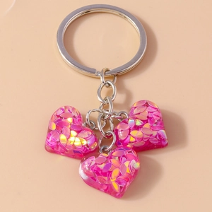 Détail de porte-clés à paillettes en forme de cœur avec trois pendentifs roses scintillants