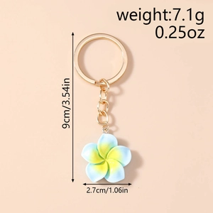 Detail showing gradient plumeria keychain dimensions and weight on warm background