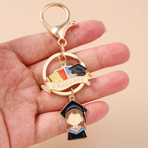Golden graduate keychain with cartoon student pendant and colored book emblem