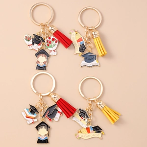 Close-up of graduation keychains with golden charms, tassels, and graduate motifs