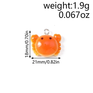 Detail view of a small orange crab charm pendant with silver loop and dimensions