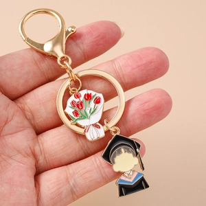 Detailed close-up of golden graduation keychain with tulip flower and student charms