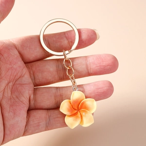 Handheld sweet gradient frangipani flower keychain with a gold metal ring and charm