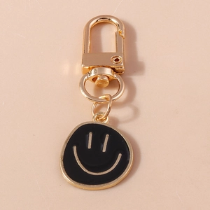 Détail du fermoir mousqueton doré et du porte-clés avec pendentif sourire en émail