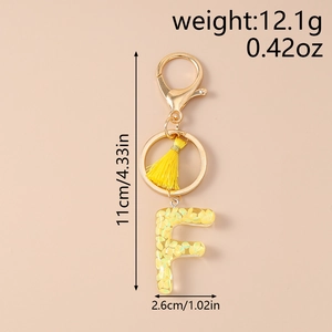 Detail view of yellow sequin letter F keychain with dimensions and weight specs