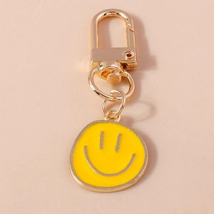 Détail du porte-clés smiley en émail jaune avec fermoir mousqueton en métal doré