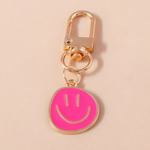 Détail du porte-clés smiley rose avec fermoir mousqueton doré en forme de U