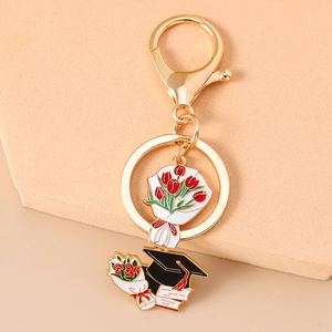 Detailed close-up of a graduation keychain featuring a floral bouquet and academic cap charm