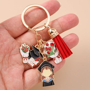 Detail of graduation keychain featuring colorful enamel charms and a red tassel accessory