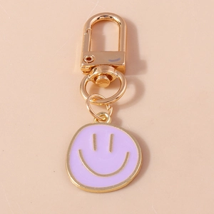 Vue détaillée du pendentif smiley en émail violet avec un fermoir mousqueton doré
