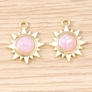 Gros plan de pendentifs soleil dorés avec résine rose scintillante pour bijoux DIY