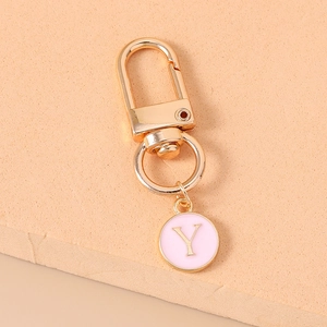 Close-up of pink enamel letter Y pendant on golden metal keychain with D-ring clasp