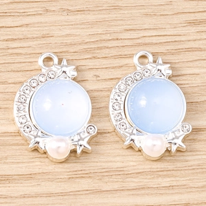 Detail of silver moon and star pendant with blue opal stone and micro-set rhinestones