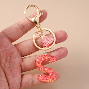 Handheld red resin letter S keychain with gold ring and pink tassel accessory