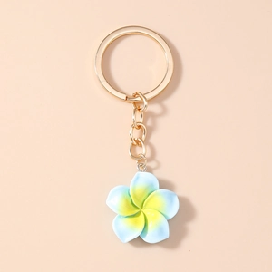 Detailed shot of gradient blue and yellow plumeria keychain with a gold metal ring