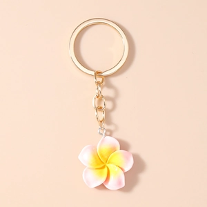 Close-up of pink gradient resin plumeria flower keychain with golden metal ring