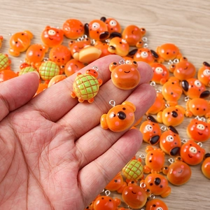 Detailed close-up of cute animal resin charms for DIY jewelry making in warm orange tones