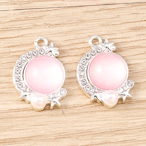 Detail of silver moon pendants with pink cat eye stone and rhinestones for DIY jewelry