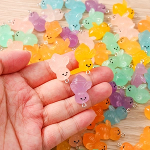 Close-up of colorful resin honeybee charms for DIY jewelry making with silver hooks