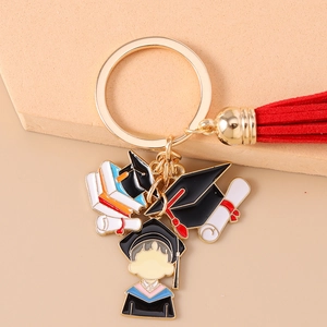 Detailed close-up of graduation keychain with tassel, books, and mini mortarboard charms