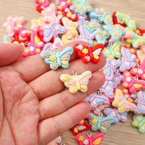 Macro shot of colorful resin butterfly charms with floral relief and silver metal rings