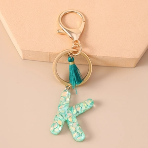 Detailed view of Letter K keychain with turquoise sequins and a green tassel