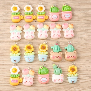 Flat lay of colorful resin flower and cactus charms with metal rings for DIY jewelry