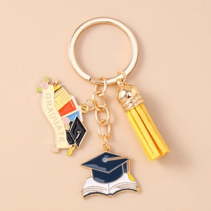 Detail view of graduation keychain with golden rings, yellow tassel, and graduate charms