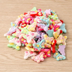 Detailed macro view of colorful resin butterfly charms with floral relief for DIY jewelry