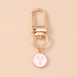 Macro detail of golden lobster clasp with pink enamel letter Y pendant keychain